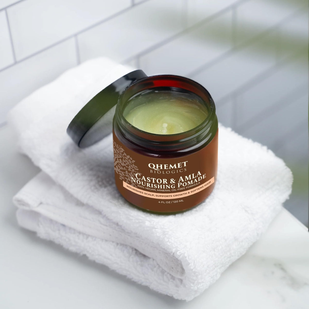 Qhemet Biologics pomade jar close-up shows creamy texture for easy detangling