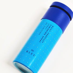R+Co BLEU humidity defense mist in action protecting styled hair.