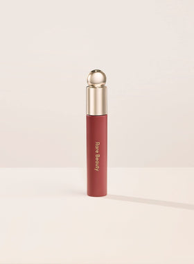 Rare Beauty Soft Pinch Lip Oil Delight bottle close-up showcases a glossy finish for a radiant pout