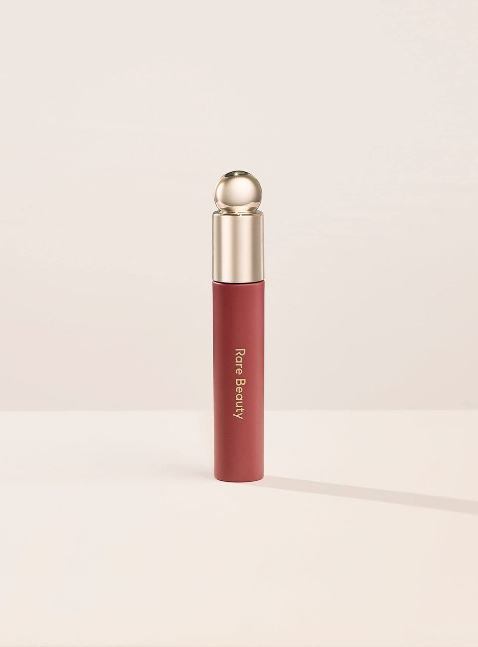 Rare Beauty Soft Pinch Lip Oil Delight bottle close-up showcases a glossy finish for a radiant pout