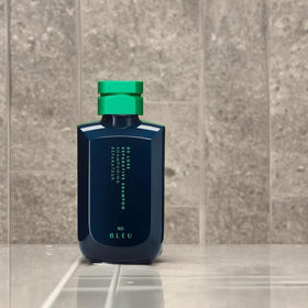 R+Co BLEU De Luxe Reparative Shampoo bathroom scene emphasizes daily clean beauty use