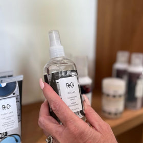 R+Co Dallas Thickening Spray mist closeup for even distribution and controlled styling.