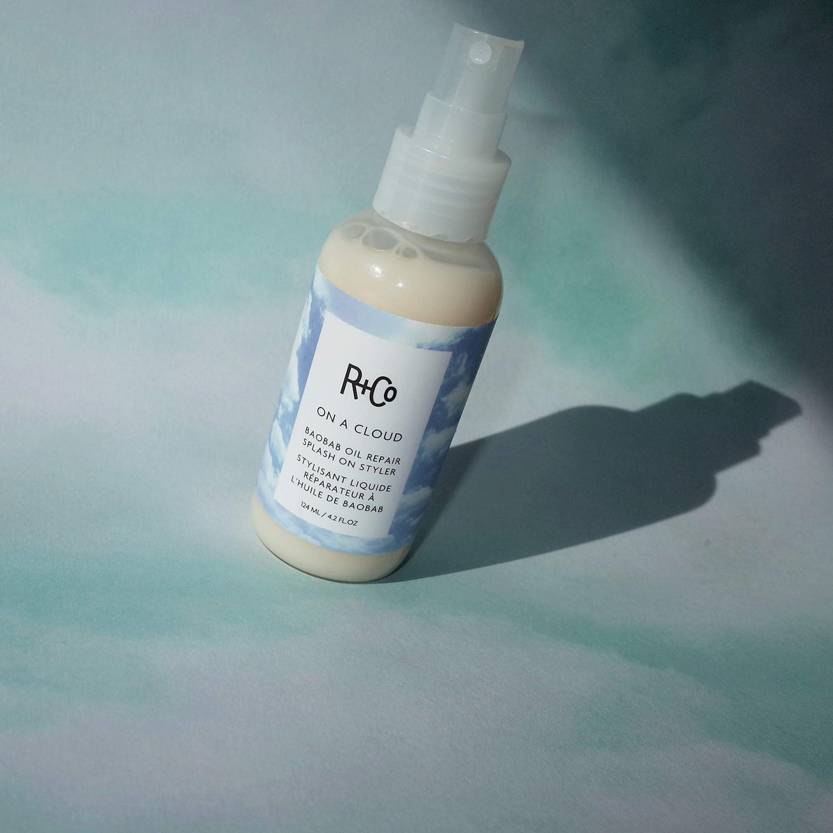 R+Co On A Cloud Baobab Oil Repair Splash texture close-up highlighting glossy, hydrated strands