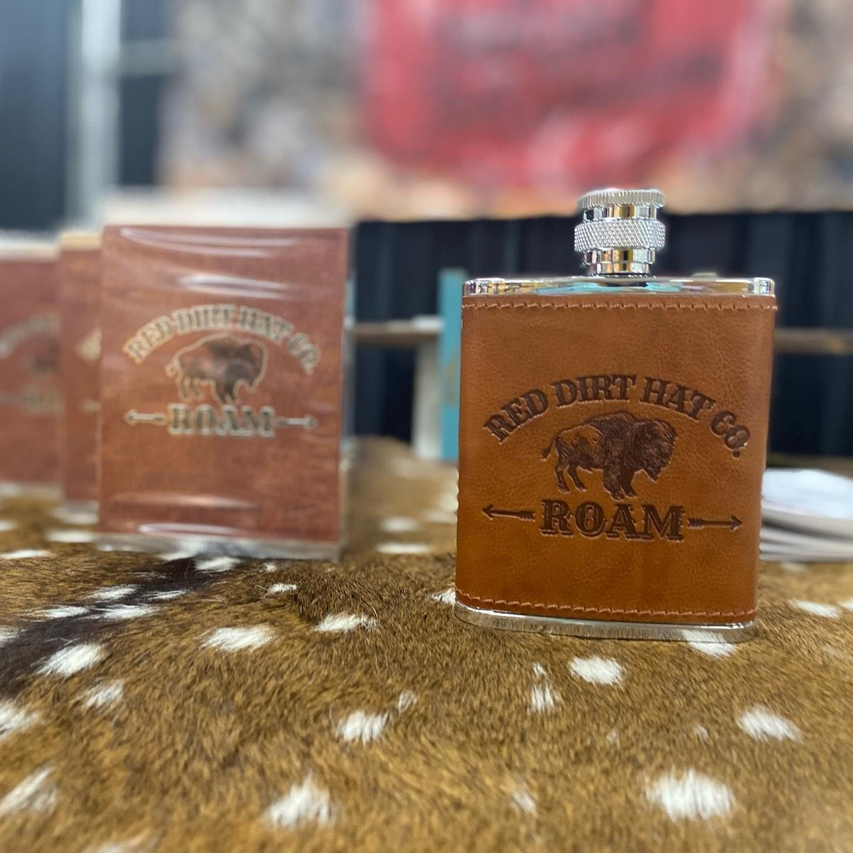 Roam bottle with spray cap beside travel case suggests easy, on-the-go use.