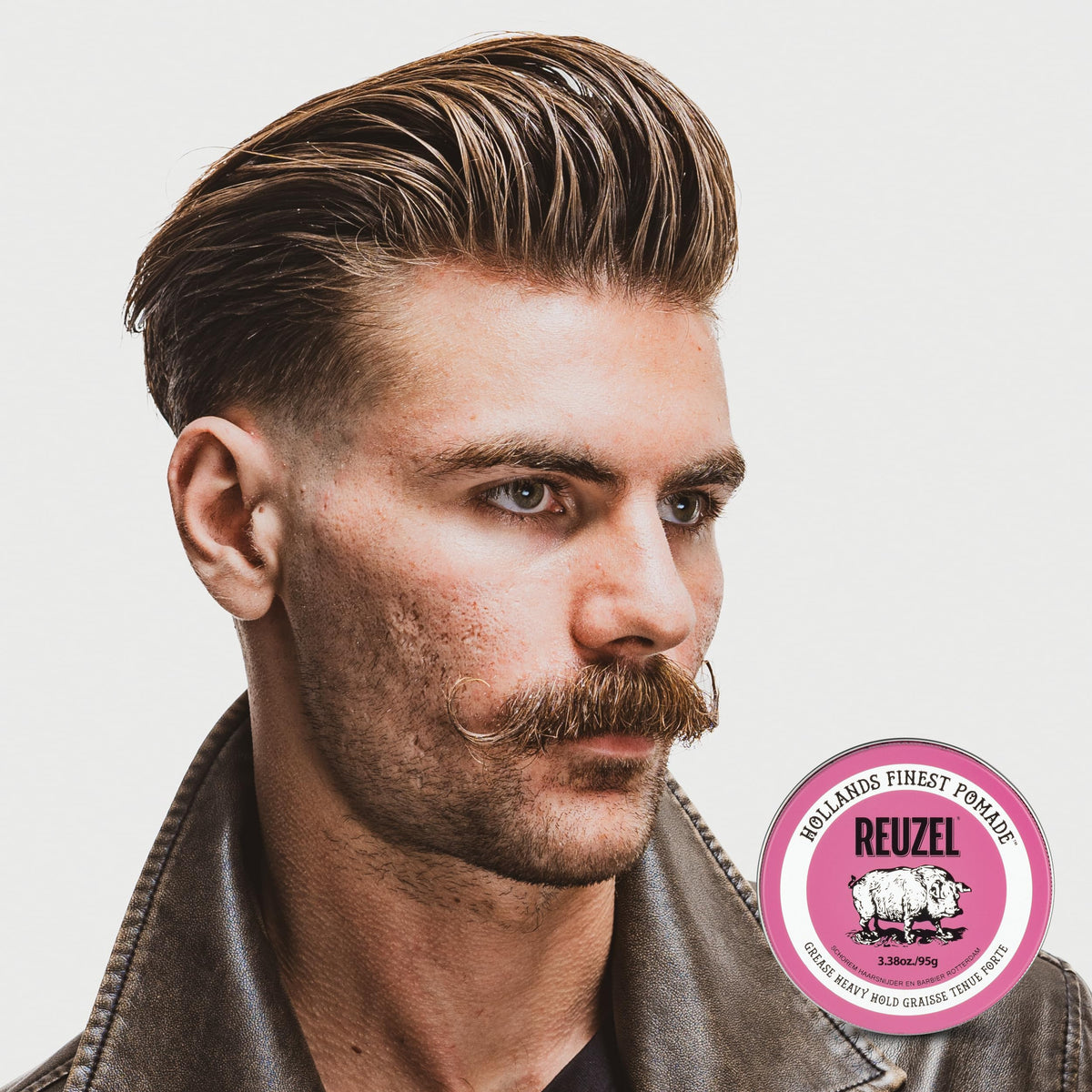 Hands applying REUZEL Pink Grease to hair for smooth styling control
