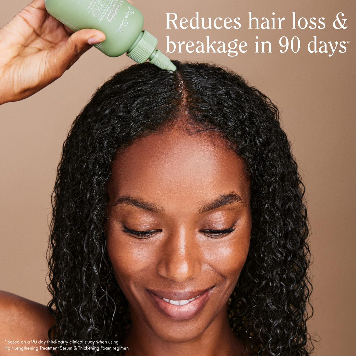 Rizos Curls lengthening serum droplets on fingertip for precise application