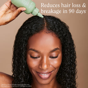 Rizos Curls lengthening serum droplets on fingertip for precise application