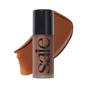 Saie Dew Bronze liquid bronzer stick close-up with doe-foot applicator for precise bronze definition.