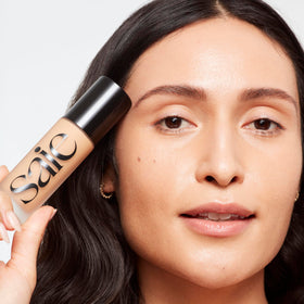 Saie Glowy Super Skin Tint application with fingers for dewy, weightless coverage