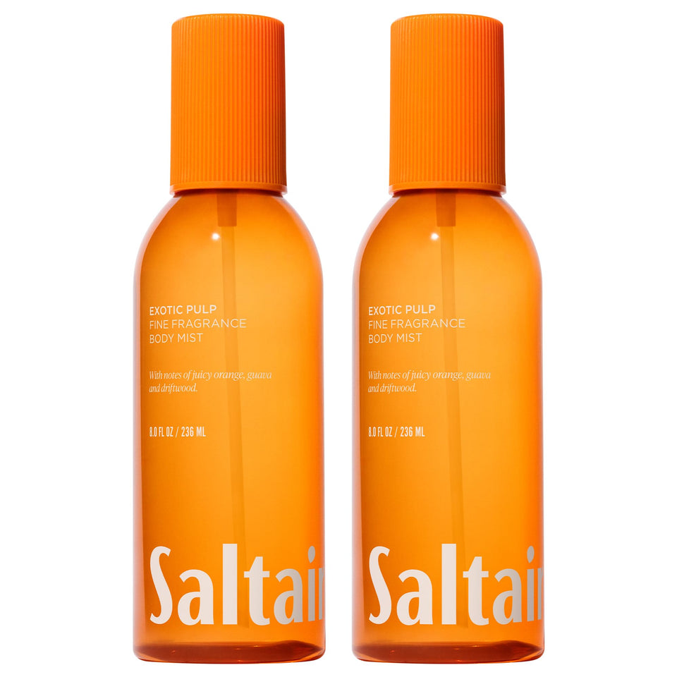 Saltair Body Mist 2-Pack bottles on a sunny beach for portable fragrance.