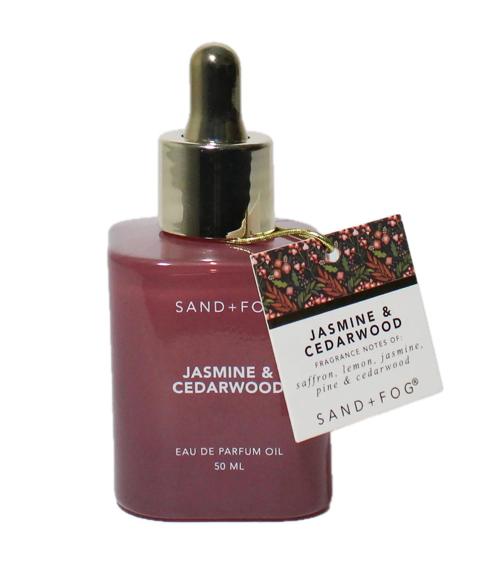 Sand + Fog jasmine-cedarwood bottle shows premium fragrance in a dark glass vessel.