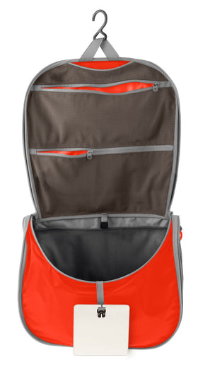 Sea to Summit hanging toiletry bag in spicy orange open shows organized compartments for cosmetics
