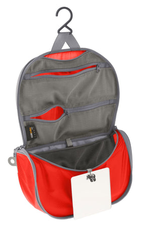 Sea to Summit small hanging toiletry bag in spicy orange, compact for minimalist packing.