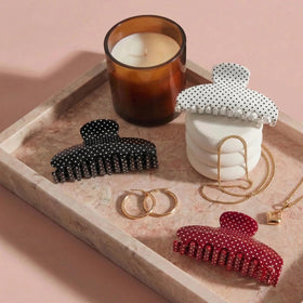 Black polka dot clip close-up highlighting strong grip for all hair types.