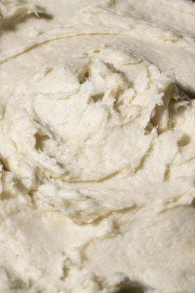 Hands applying Shea Radiance P U R E whipped butter for daily moisture