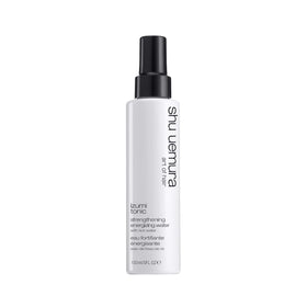 The shu uemura art of hair Izumi Tonic bottle close-up highlighting strengthening rice water benefits.
