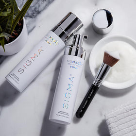 Sigma Beauty Sigmagic Foam rinsing a brush under water for residue-free finish