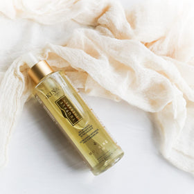 Close-up of product on bathroom shelf next to skincare.