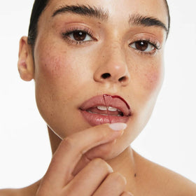 Smooche Lip Stain Raspberry Kiss application closeup shows easy peel-off activation.