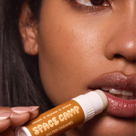 Space Camp Wellness Jumbo Lip Balm Strawberry Frosting being applied for smooth lips.