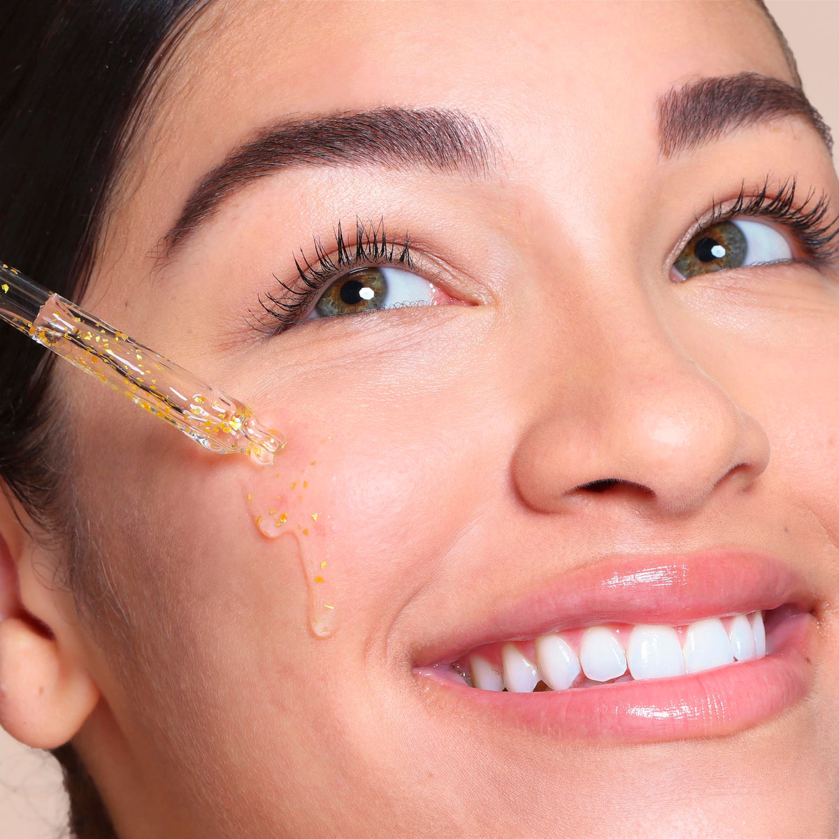SpaLife 24k Gold Serum on cheek for hydrated glow.