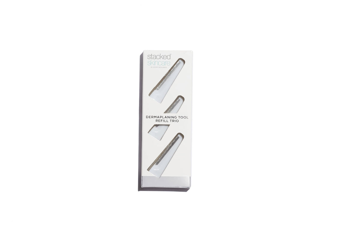 Close-up of StackedSkincare dermaplaning blades with protective cap for easy blade swap.