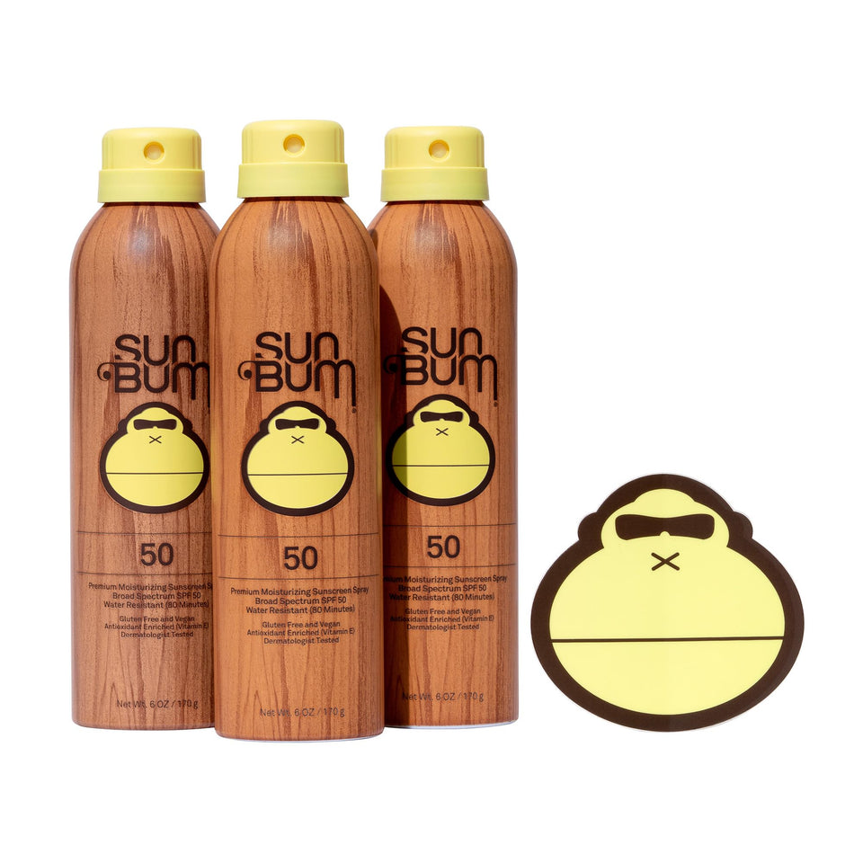 Sun Bum Original Sunscreen Spray bottle on the sand offering broad spectrum protection.