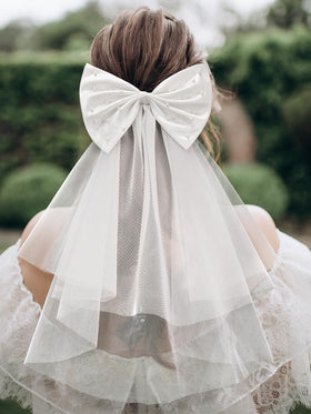 SweetV white satin bow close-up showing fixed pearls for lasting sparkle.