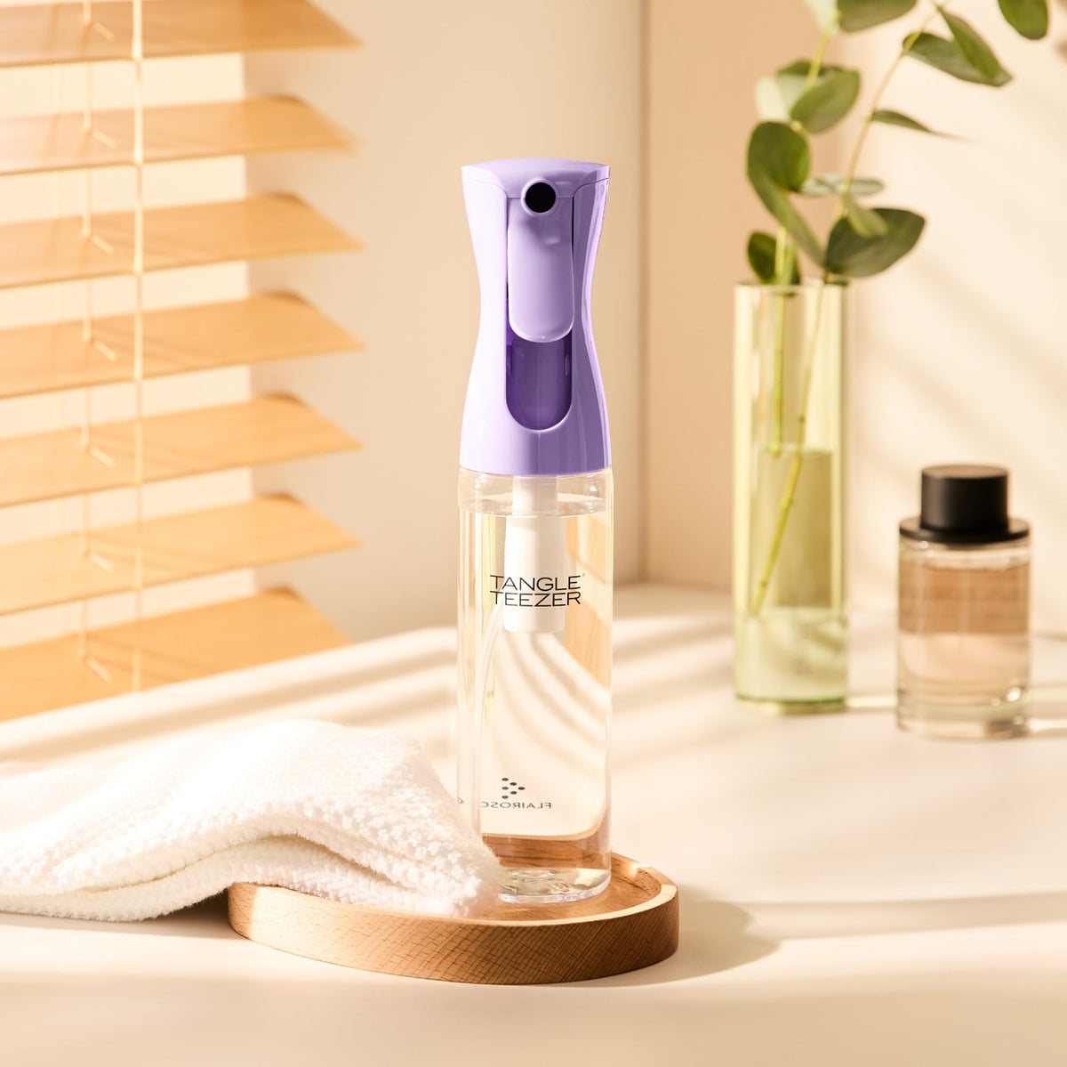 Tangle Teezer Fine Mist Bottle applying mist to strands during styling.
