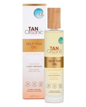 TanOrganic Self Tanning Oil bottle on wood surface showing natural glow