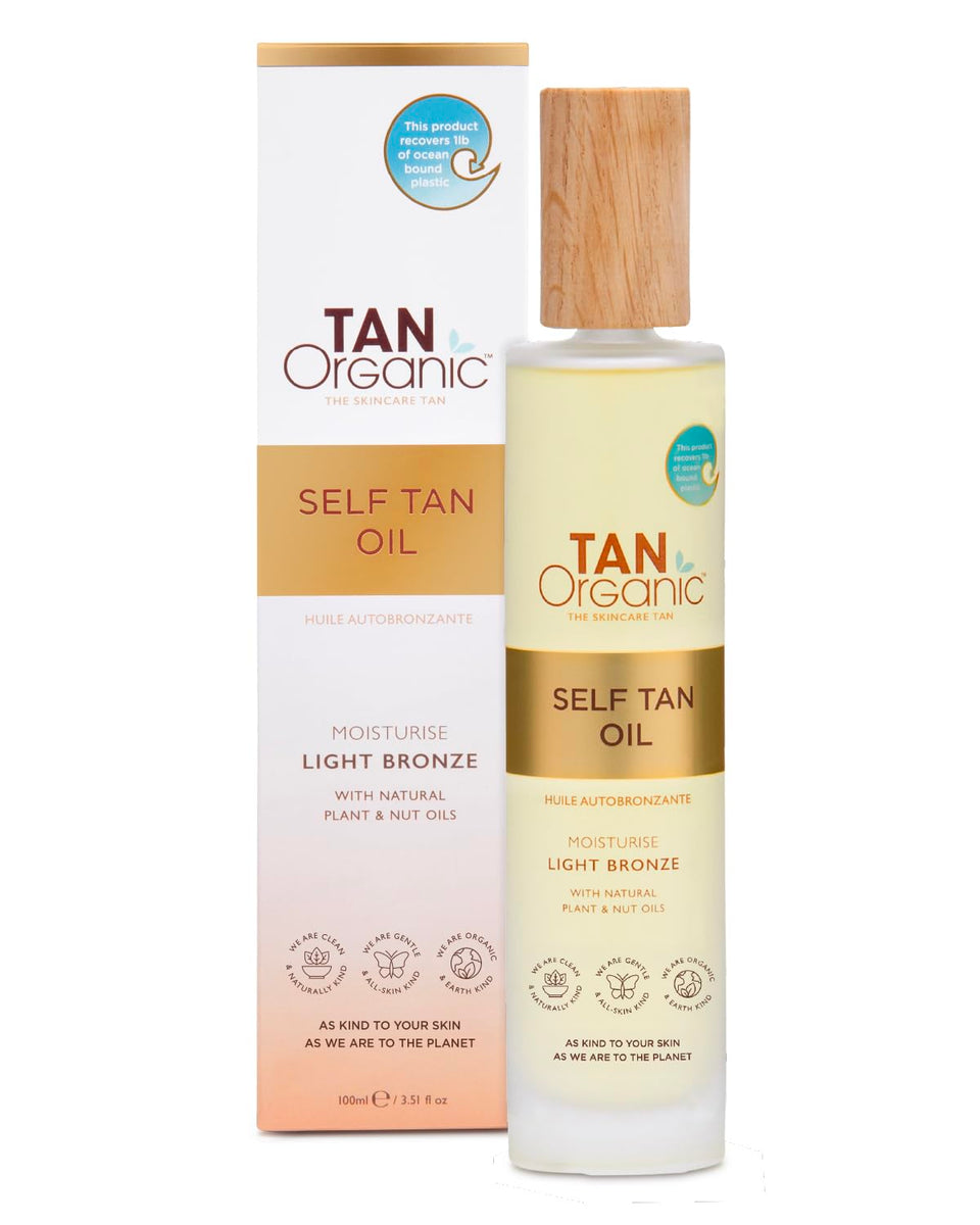 TanOrganic Self Tanning Oil bottle on wood surface showing natural glow