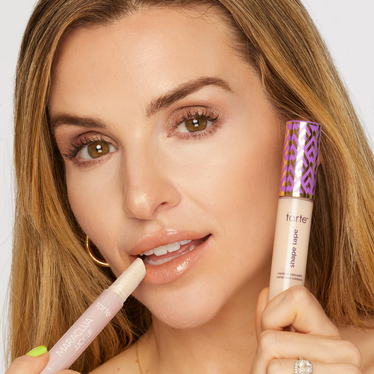 tarte lip balm on lips with mirror-shine finish.