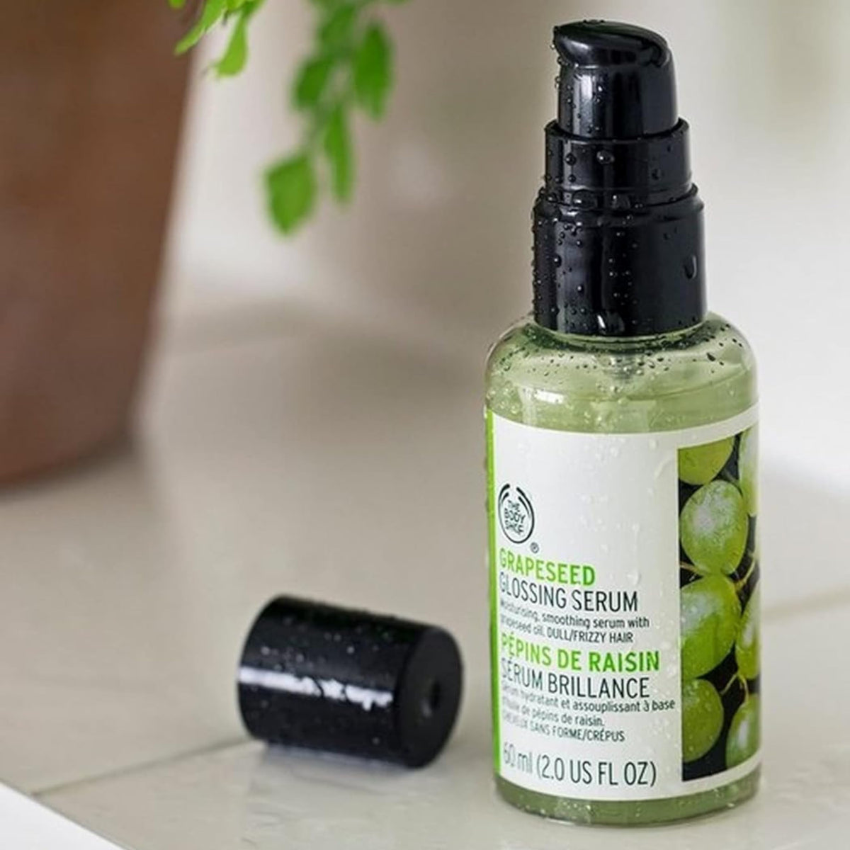 Applying The Body Shop Grapeseed Glossing Serum for even distribution and frizz control
