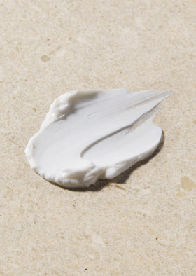 The Body Shop Vitamin E Night Cream on a bedside table hints at overnight hydration.