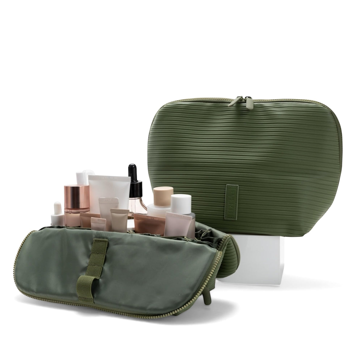 THE VERTI olive medium vertical bag open, showing organized pockets for skincare and toiletries