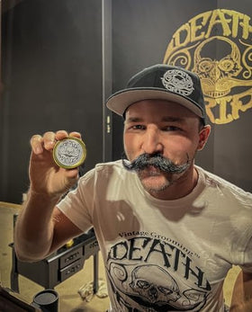 The Vintage Grooming Co. Black Magic Mustache Wax packaging highlights compact, travel-friendly design.