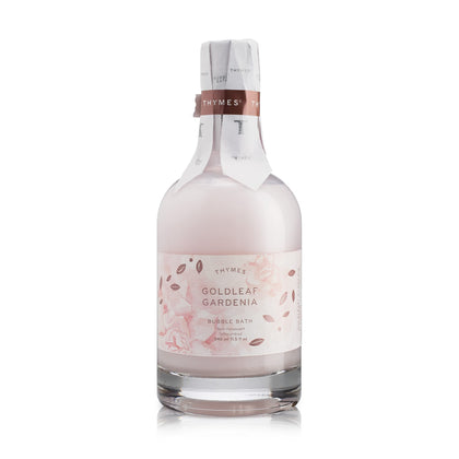 Thymes Bubble Bath Goldleaf Gardenia bottle on a bathroom shelf ready to start a relaxing soak