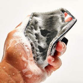 TOOLETRIES charcoal body scrubber in shower shows durable silicone design.