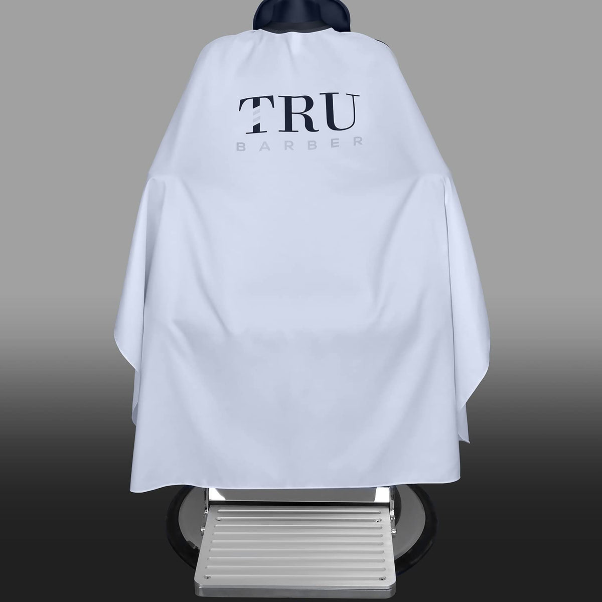 TRU BARBER cape with secure snap closure for adjustable fit and quick fastening.