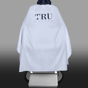 TRU BARBER cape with secure snap closure for adjustable fit and quick fastening.