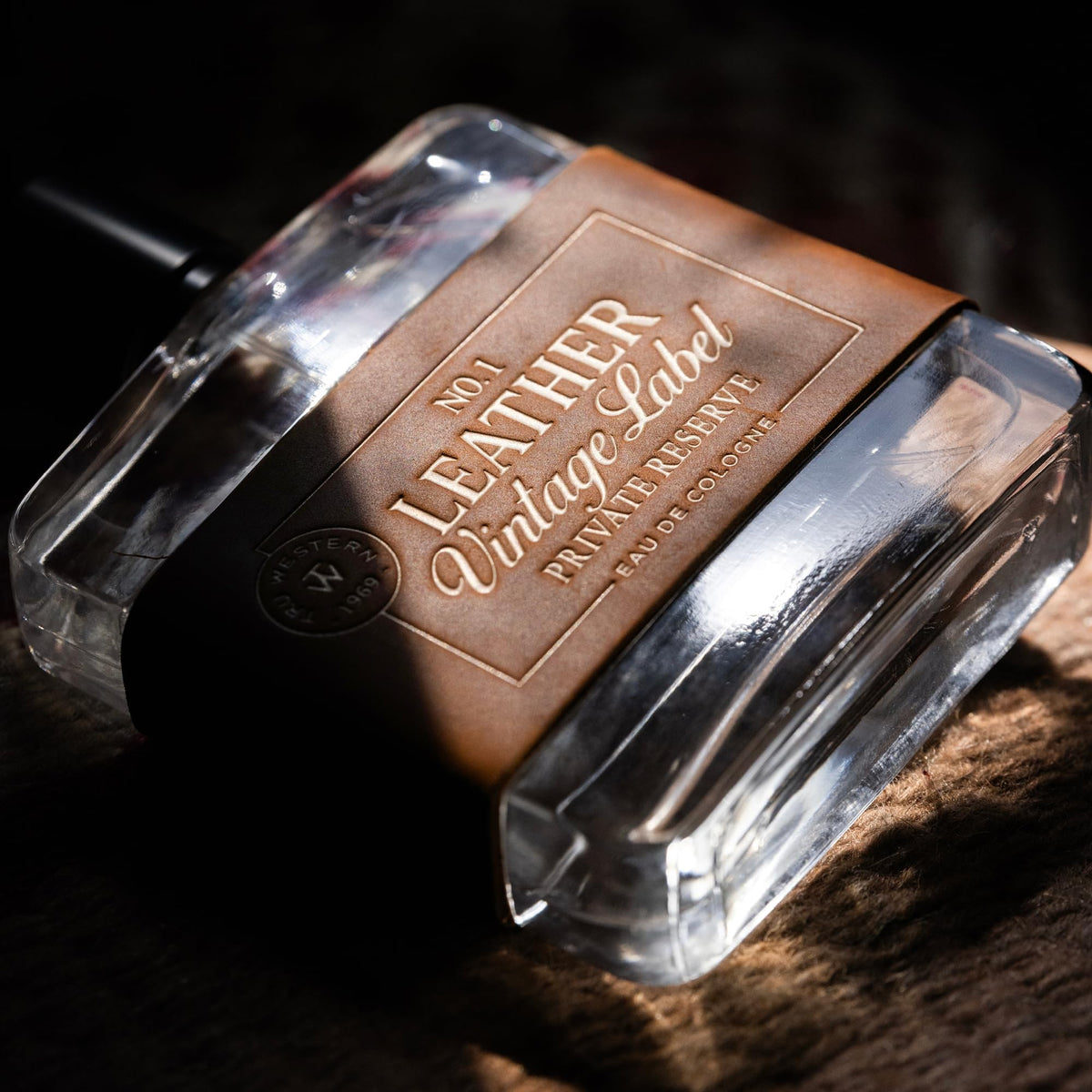Tru Western Leather No. 1 bottle on a wood backdrop suggesting rugged yet refined aroma.