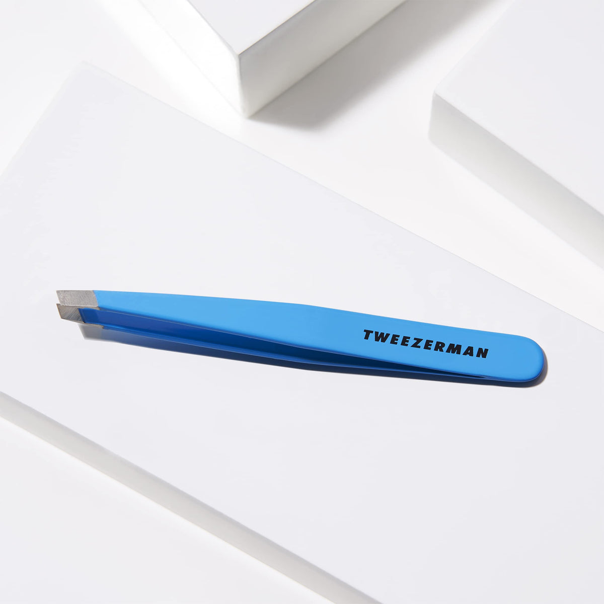 Tweezerman brow tool in action removing hairs along the brow line.