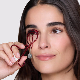 Tweezerman Devil Wears Prada 2 lash curler in use for a wide-awake look.