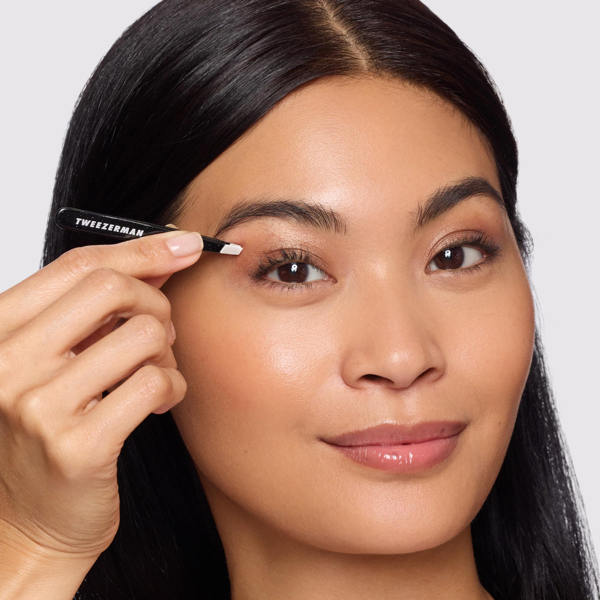 Tweezerman Mini Slant Tweezer travel size shown in compact kit