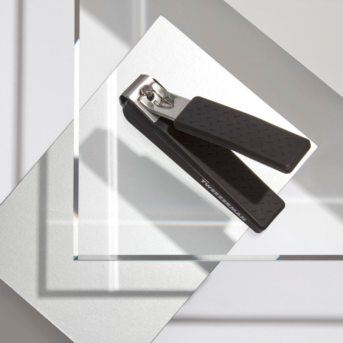 Tweezerman precision grip blades close-up show curved edges for natural nail shaping.