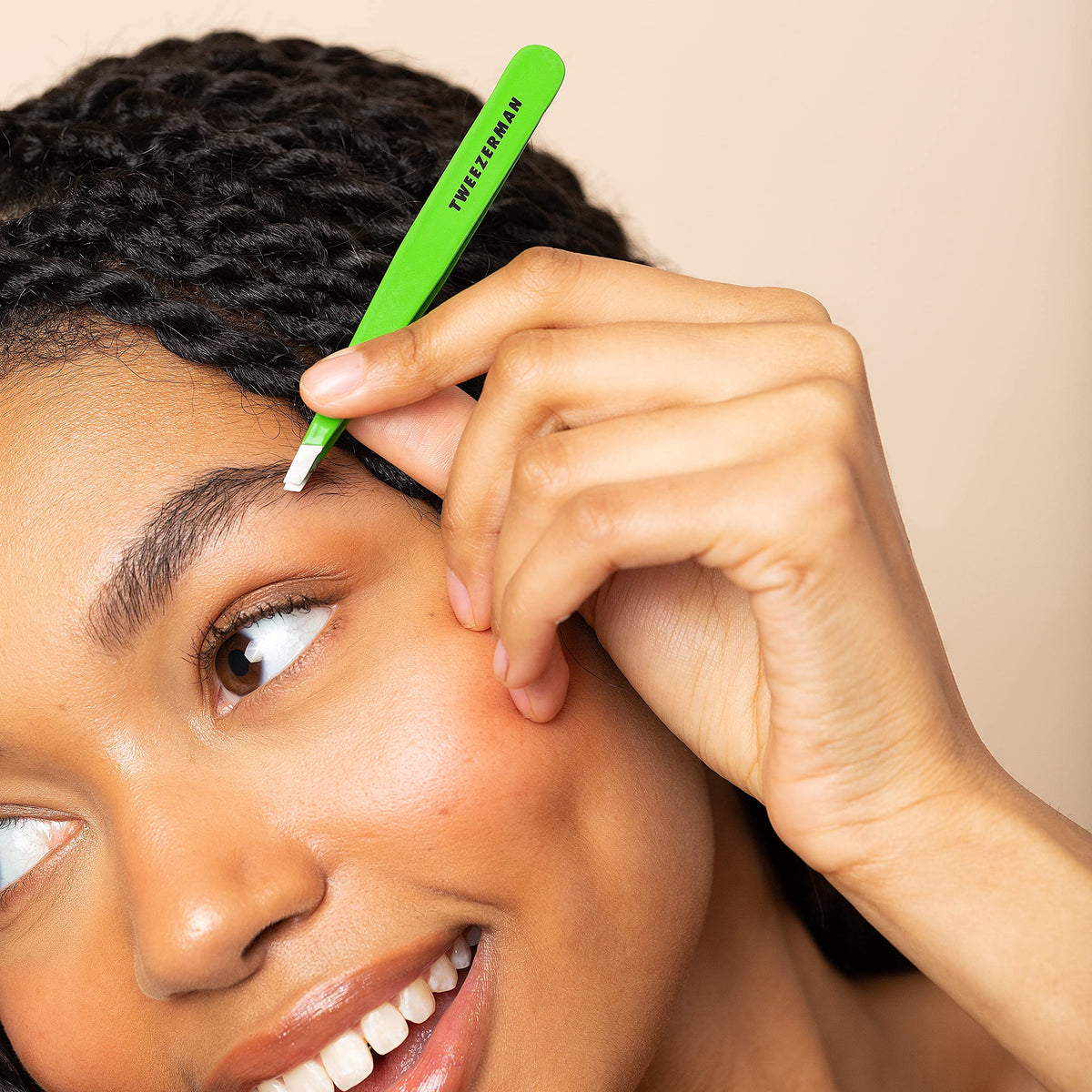 Tweezerman Slant Tweezer Green Apple in use, showing controlled grip for easy grooming