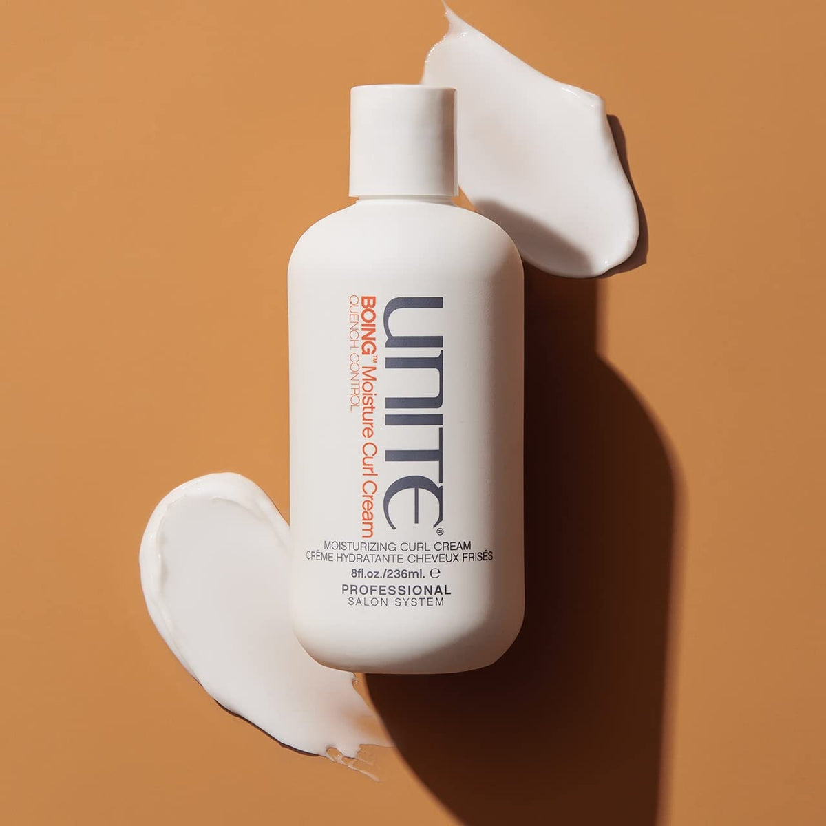 Hands apply UNITE BOING Moisture Curl Cream for defined curls without crunch