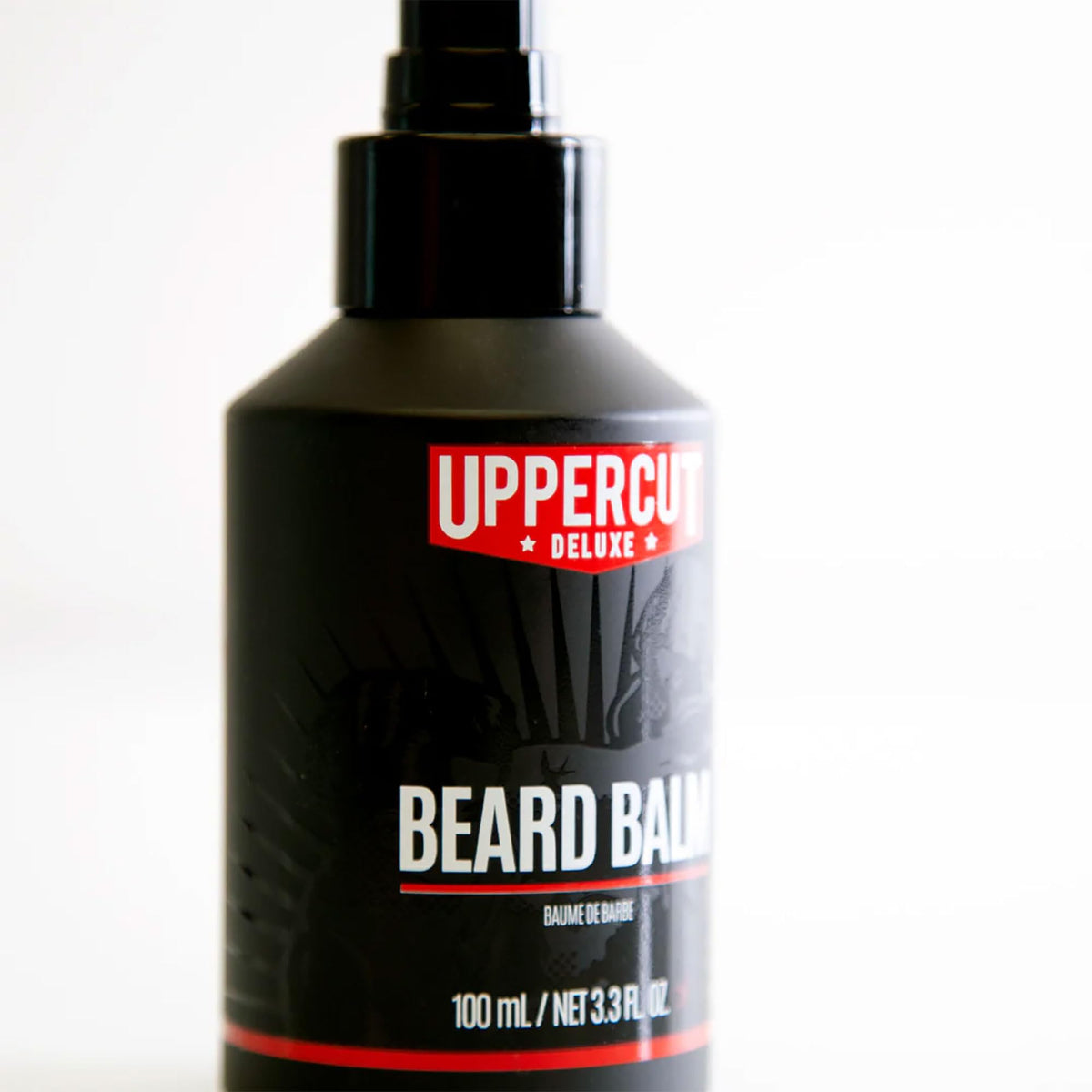 Hands applying Uppercut Deluxe beard balm for a natural finish.
