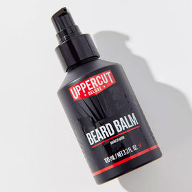 Beard balm being worked into beard for controlled shaping with Uppercut Deluxe.