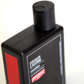 Uppercut Deluxe Strength & Restore conditioner bottle back showing ingredients